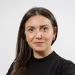 A woman in a black top posing for a photo as part of our team.